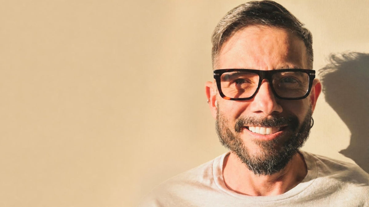 Hombre sonriendo con lentes de acetato carey
